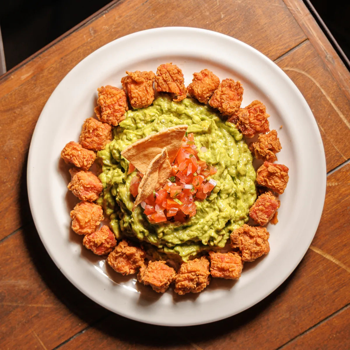 Plato de guacamole con pico de gallo y bocados dorados en Patio Península